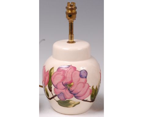 A modern Moorcroft pottery table lamp, in the Magnolia pattern, underglaze painted and tube-line decorated on a cream ground,