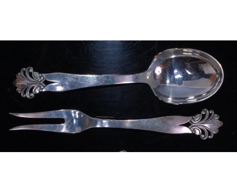 A Danish early 20th century sterling silver cheese fork and serving spoon by Orla Vagn Mogensen, each having pierced floral s