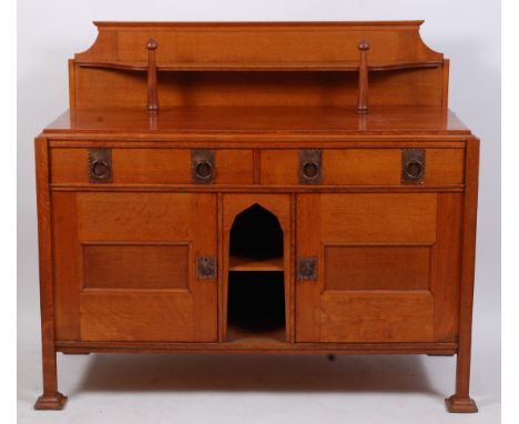 An Arts & Crafts oak ledgeback sideboard, by The Bath Cabinet Makers, probably designed by George Elwood, having turned uprig