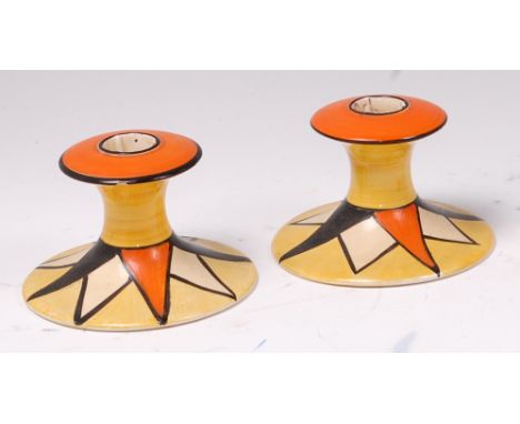 A pair of 1930s Clarice Cliff original Bizarre pattern pottery squat candlesticks, each bright colour painted on spreading ci