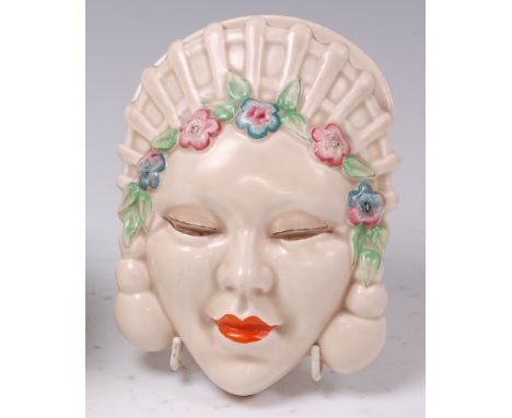 A 1930s Clarice Cliff pottery Marlene wall mask, the floral headband and lips painted in bright colours, stamped 'Clarice Cli