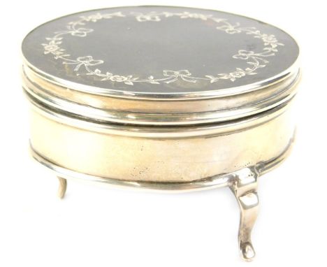 A George V silver, tortoise-shell and pique work circular trinket box, the hinged lid enclosing a fitted interior, on scrolli