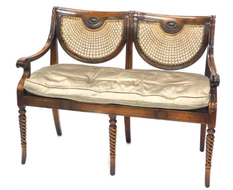 A mahogany two seat sofa, with a bergere cane shaped back and seat, shaped arms, on spirally turned legs, 113cm W