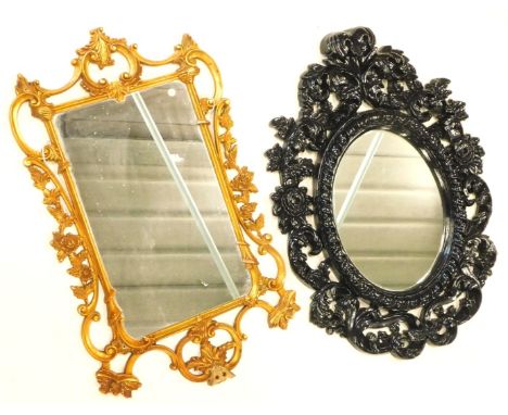 A black painted rococo scroll wall mirror, with oval plate and a Chippendale style mirror in plastic frame.  (2)