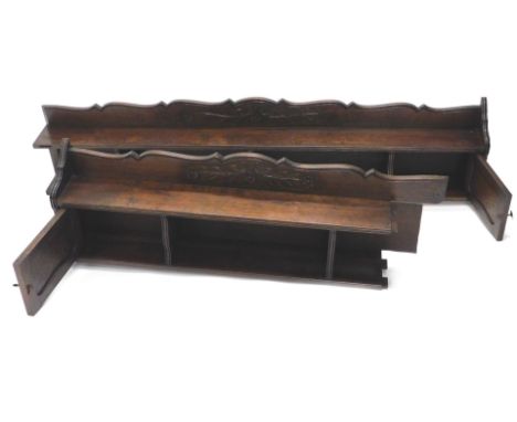 An oak wall shelf, with a shaped top, with two panelled doors and various recesses, in two parts, 309cm W.