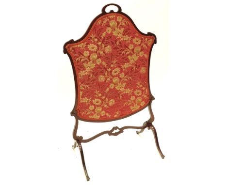 An Edwardian mahogany cartouche shaped firescreen, with a floral fabric banner, on shaped supports, 67cm W.