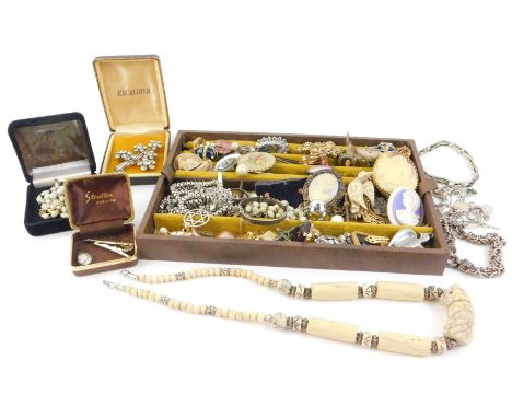 A brown leather jewellery box and contents, to include a silver charm bracelet, a claw bar brooch, clip on earrings, silver d