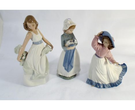 A collection of three Nao porcelain figurines of girls 