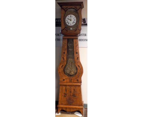 A French long case clock in oak case with floral carved front, a circular enamel and brass dial with striking movement 