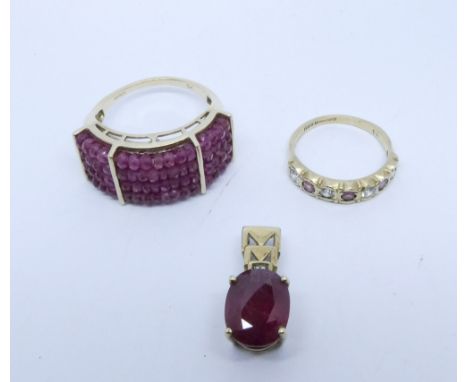 A large 9ct yellow gold and ruby set dress ring 9ct gold ruby pendant and a 9ct half hoop ring set red and white stones 