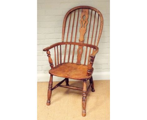 An antique stick back Windsor elbow chair on turned legs 