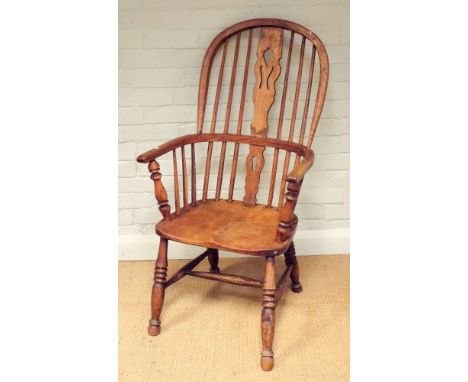 An antique stick back Windsor elbow chair on turned legs 