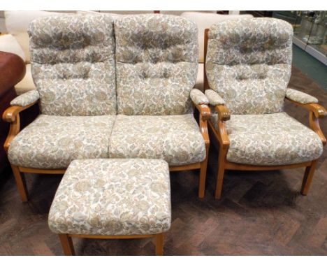 An Ercol light oak framed two seater settee in buttoned floral patterned material together with one matching chair and a stoo