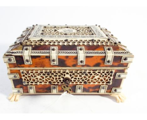 19th century tortoiseshell and bone overlaid box, the slightly domed lid with carved panel depicting a wolf. Raised on claw f