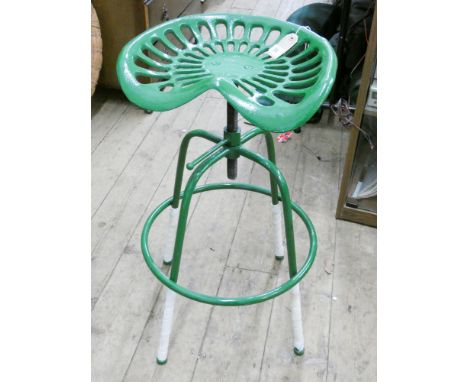 A cast iron adjustable tractor seat on stool base in green 