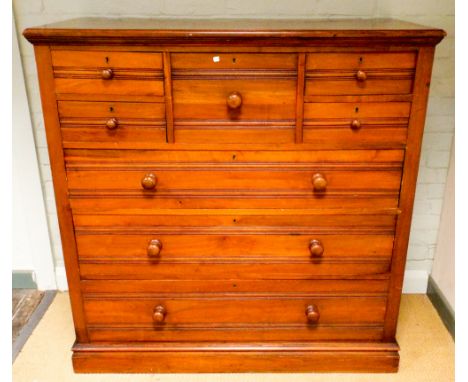 An Edwardian walnut scotch chest of three long, four short drawers and a hat box centre drawer with bun handles 122cms wide, 