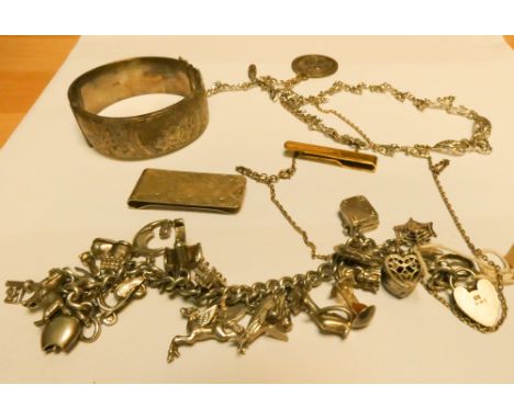 A silver charm bracelet, silver bangle, money clips etc 