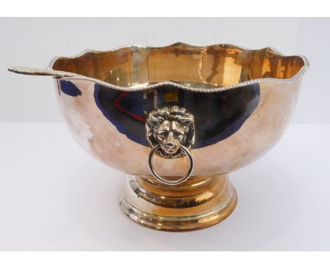 A silver-plated punch bowl with lion's head handles and ladle (32 cm wide x 21 cm high)