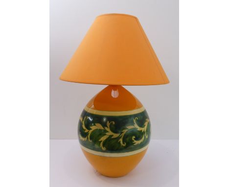 A Louis Drimmer ceramic table-lamp and shade: orange ground with a green band of foliate decoration; signed to the base of th