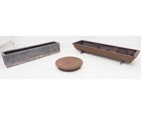 Two planters and a coal-hole cover:1. a late 19th century cast iron pig trough (92 x 27.5 x 15 cm);2. a faux lead window-box 