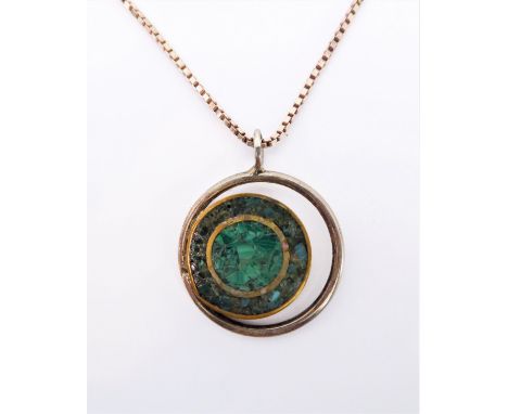 A circular silver pendant with central section comprised of malachite and turquoise re-constituted pieces, suspended from a s