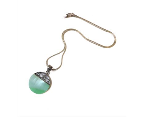 A pierced circular silver pendant: the lower two-thirds mounted with a opalescent polished hardstone (as Jadeite) suspended f