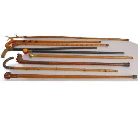 Nine walking sticks to include two with carved animal head handles and a bamboo example with niello work style silver-coloure