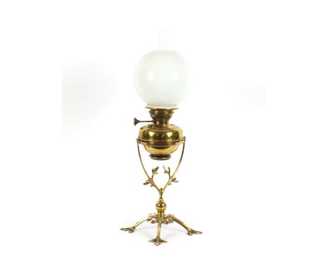 A brass table oil lamp, in the style of W.A.S.Benson, the base in the form of ivy leaves, white opaque globular shade, 72cm h
