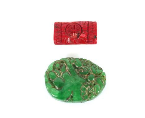 A coral coloured hardstone pendant; and a green jade coloured carved pendant 