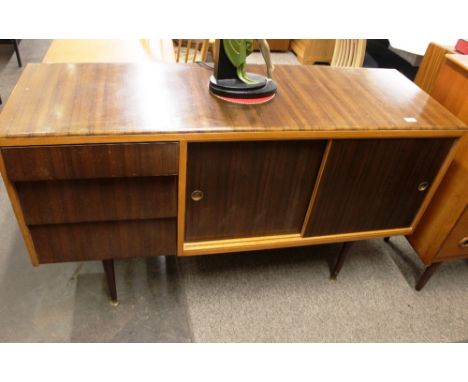 A 1960's walnut and teak sideboard, having three louvre shaped drawers and interior shelf enclosed by a pair of sliding doors