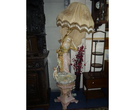 A DECORATIVE CERAMIC STANDARD LAMP / WATER FEATURE, modelled as a young lady with cherub