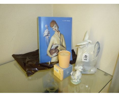 A LLADRO SOCIETY NAME STAND, a Lladro Dog, a boxed Lladro candle, a book and a bag