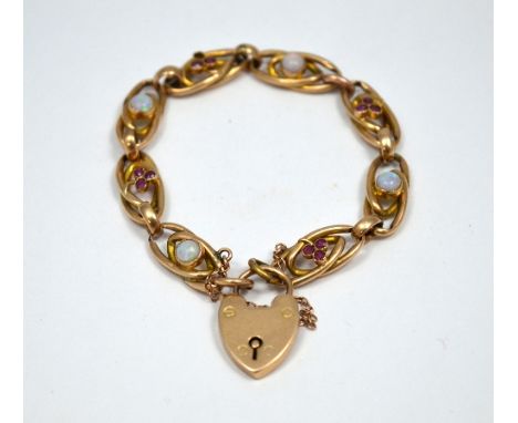 A 9CT GOLD EDWARDIAN BRACELET, each link of open work design with opal and ruby detail, with heart shape padlock clasp and sa