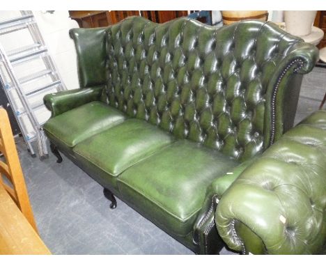 A GREEN LEATHER BUTTON BACK THREE SEATER SOFA