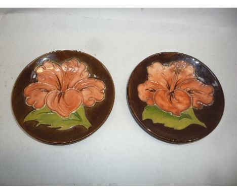 TWO MOORCROFT POTTERY TRINKET DISHES, Hibiscus pattern, impressed marks and a paper label to one (2)