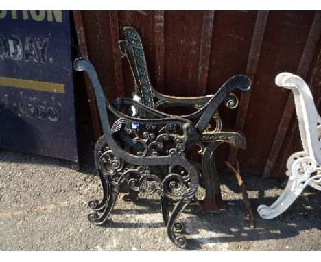 A PAIR OF PAINTED CAST IRON BENCH ENDS, with lion detail and another pair of cast iron bench ends (4)