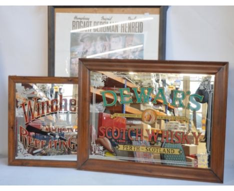 Two decorative mirrors to include Dewar's Scotch Whiskey (81.7x64cm) and Winchester Repeating Arms (68x52.5cm). Also included