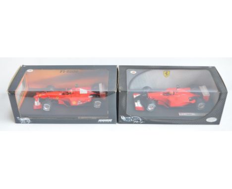 Two 1/18 scale diecast Michael Schumacher Collection F1 Ferrari models from Hot Wheels Racing with seated driver figures to i