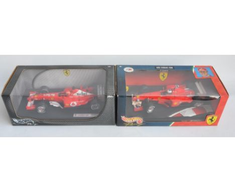 Two 1/18 scale diecast Michael Schumacher F1 Ferrari models from Hot Wheels Racing with seated driver figures to include 2462