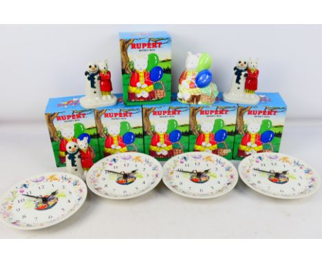Six boxed Rupert The Bear ceramic money banks, four Wedgwood wall clocks and three Camtrak's Childhood Favourites figure grou