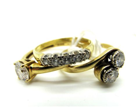 An 18ct Gold Two Stone Diamond Set Ring, claw set between crossover shoulders; Together with Two 18ct Gold Dress Rings. (3)