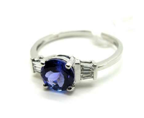 A Modern 18ct White Gold AAA Tanzanite and Diamond Ring, circular four claw set to the centre, between tapered baguette set s