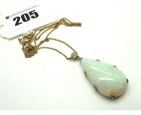 A Large Opal Pendant, of teardrop shape, claw set below old cut diamond collet rubover set surmount, to integral fine chain.