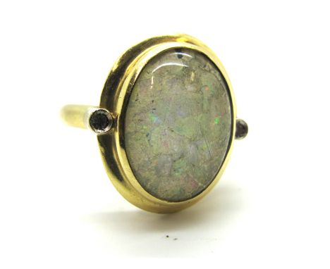 An Opal Set Dress Ring, oval set to the centre with mosaic style opal panel, under oval dome, between two illusion set diamon