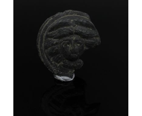 ITEM: Medusa head appliqueMATERIAL: BronzeCULTURE: RomanPERIOD: 2nd - 3rd Century A.DDIMENSIONS: 25 mm x 38 mm diameterCONDIT