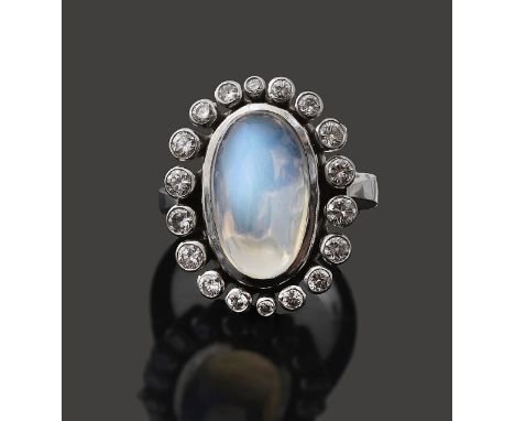A Moonstone and diamond ring central oval cabochon moonstone within a round brilliant cut diamond surround, of graduating for