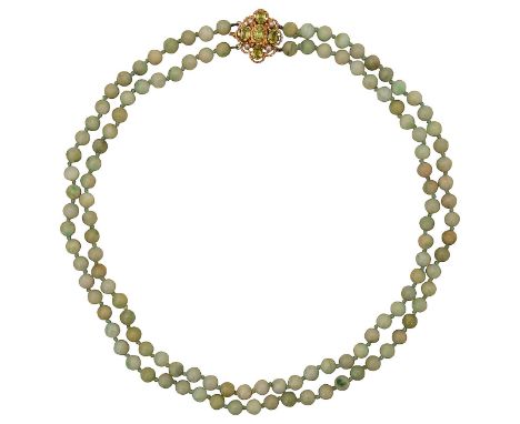 A double strand of jade beadsof uniform size, with 9ct gold peridot and pearl clasp, in a rope-twist open work design total a