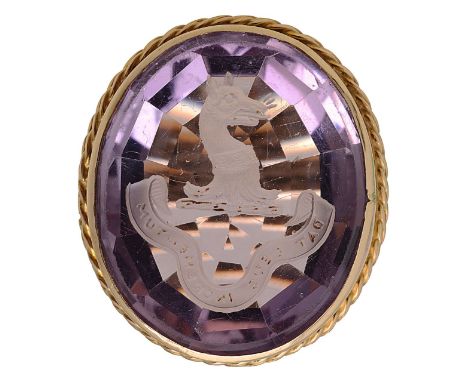 An amethyst intaglio ringlarge central mix-cut amethyst, carved with the crest of an animal head above the inscription 'DAT D