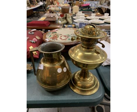 A LARGE BRASS JUG AND A BRASS OIL LAMP BASE 