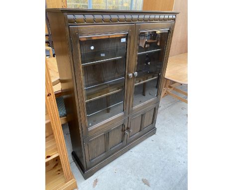 AN ERCOL GLAZED TWO DOOR BOOK CASE WITH CUPBOARD TO THE BASE, 39.5" WIDE, 54.5" HIGH 